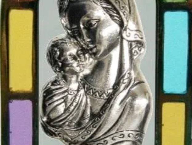 Silver statue of Mary and Jesus with stained glass panels
